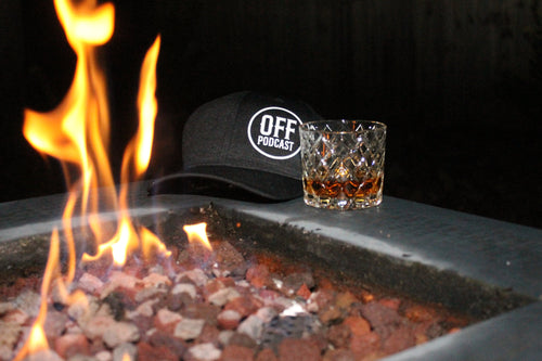 Lifestyle shot of hat with bourbon by fire